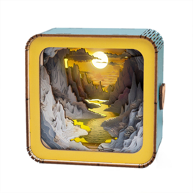 3D wooden puzzle night light featuring a sunset over a river, illuminated within a decorative box.