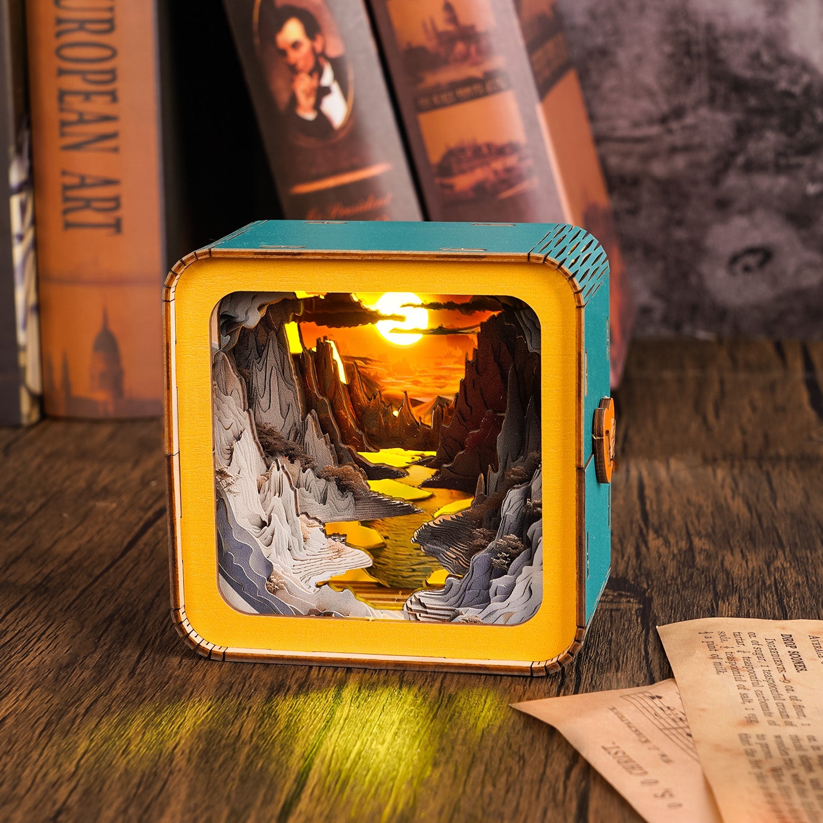 3D wooden puzzle night light depicting a sunset over a river, illuminated inside a colorful box design.