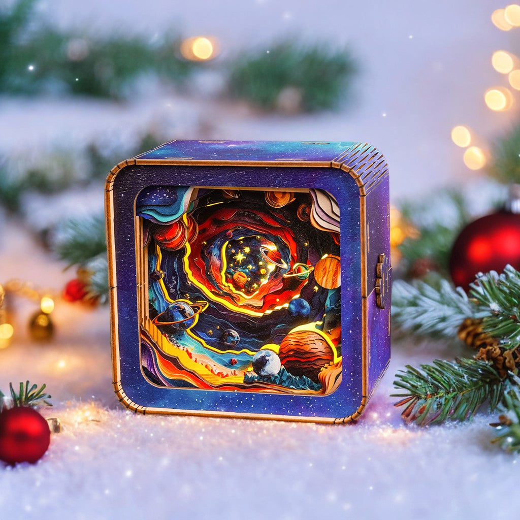 Colorful 3D wooden puzzle night light featuring a cosmic scene, surrounded by holiday decorations and greenery.