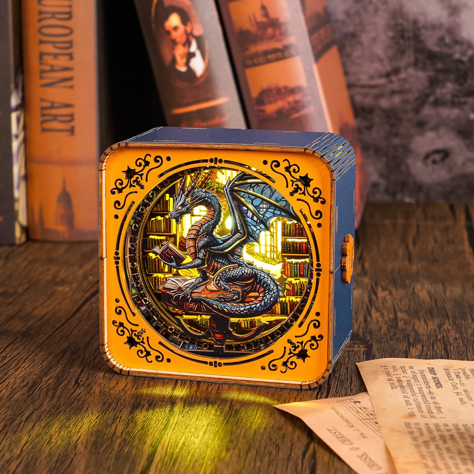 3D wooden puzzle night light featuring a dragon surrounded by books on a wooden table with vintage books in the background.