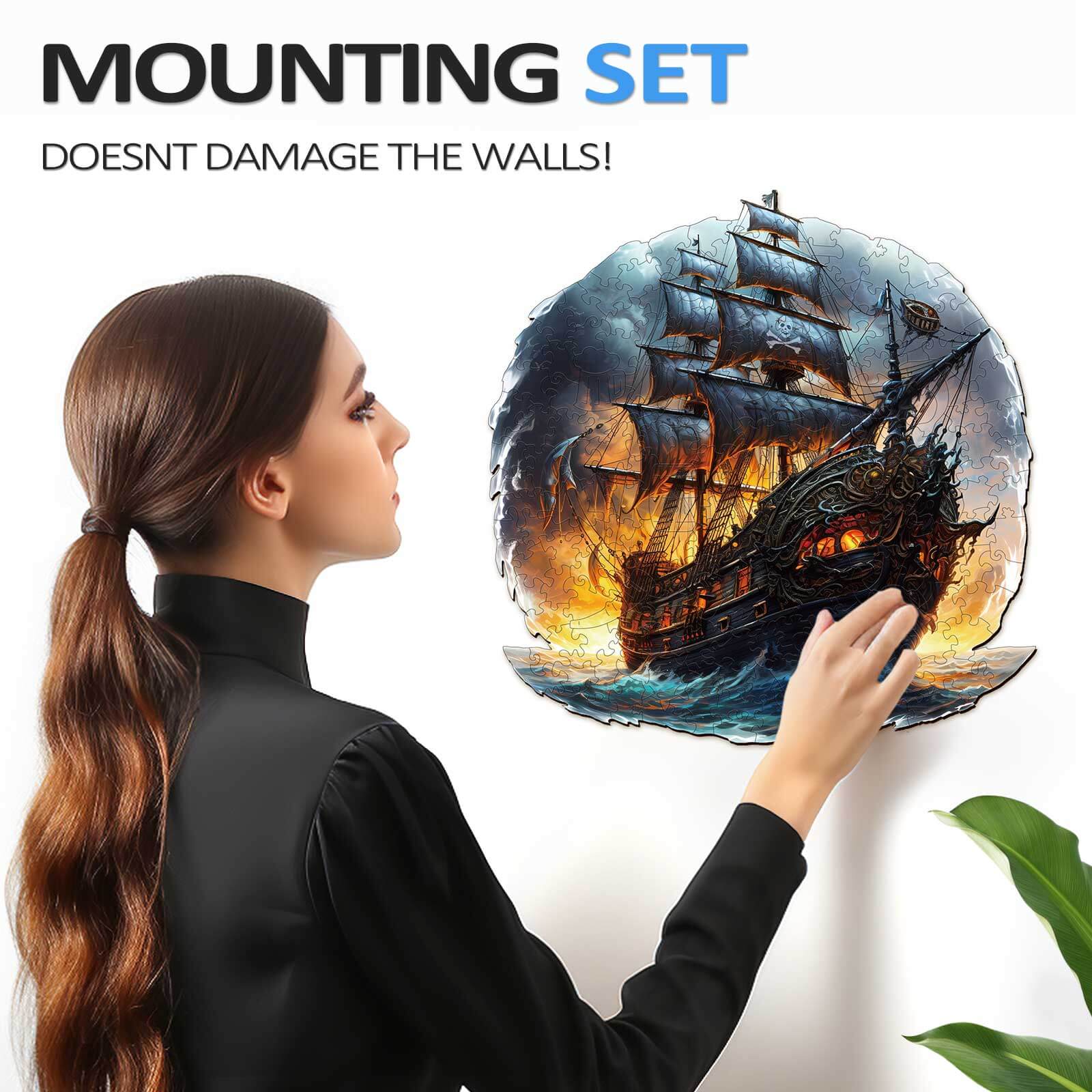 Woman applying a wall-mounted sailing ship design with a mounting set that doesn't damage walls.